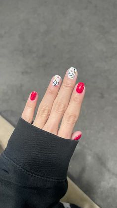 a woman's hand with red and white nail polish holding up her fingers to the camera