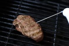 a steak being cooked on the grill with a toothpick in it's mouth