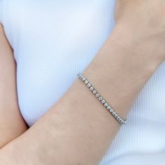 Up your game with our Charlotte Bezel Set Bracelet, featuring a flexible, continuous line of sparkling gemstones with a box and tongue clasp. A luxurious "tennis style" design made famous by tennis champion Chris Evert, who wore hers during the 1987 US Open. Both sporty and chic, this versatile bracelet style fits our modern classic aesthetic perfectly. Cubic Zirconia 14k gold vermeil, or rhodium finished sterling silver 3mm diameter stones Nickel free Comes in a signature pouch with box Remove Luxury Classic Tennis Bracelet With Bezel Setting, Luxury Cubic Zirconia Tennis Bracelet With Sparkling Stones, Luxury Modern Cubic Zirconia Tennis Bracelet, Modern Luxury Bracelets With Bezel Setting, Luxury Classic Sterling Silver Bracelet With Sparkling Stones, Luxury Classic Flexible Tennis Bracelet, Luxury Flexible Classic Tennis Bracelet, Luxury Modern Bracelets With Bezel Setting, Luxury Nickel-free Silver Bracelets