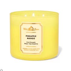 a candle that is yellow with white writing on it and the words pineapple mango