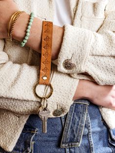 a close up of a person's arm wearing a bracelet with a key on it