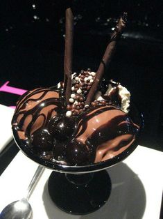 an ice cream sundae with chocolate and marshmallows in it on a table