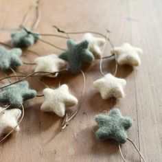 small felt stars are strung up on a wooden table