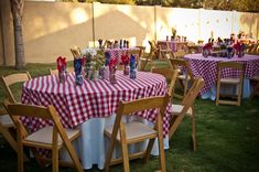 the table is set up with red and white checkered cloths for an outdoor party