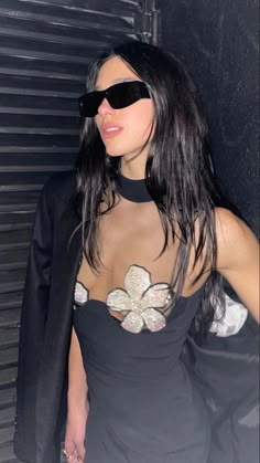 a woman wearing sunglasses and a black dress