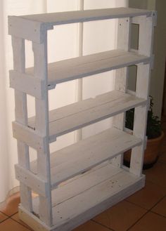 a white shelf sitting on top of a tiled floor