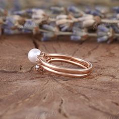 two rings with pearls are sitting on a piece of wood