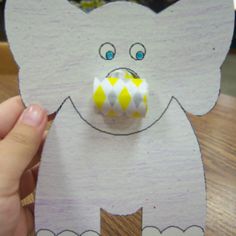 a paper cut out of an elephant with a candy in it's mouth