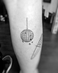 a person with a tattoo on their leg that has a globe and stars around it