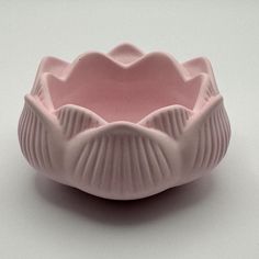 a pink bowl sitting on top of a white table