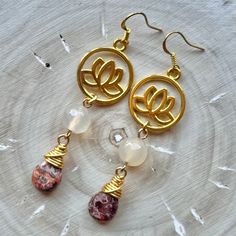 These earrings are comprised of gold plated lotus charms, Agate beads and gold wire-wrapped Leopardskin Jasper teardrops. They are 2.875'' in length including their gold plated ear wires and have a 2.5'' drop. At only 0.4 ounces, they are very lightweight and perfect for extended wear! Nickel and Lead Free.  ------------------------------ All of my jewelry pieces come in a stylish drawstring pouch, ready to wear or gift! Items will ship within 1-3 business days after an order is placed and are always packed with care & love in a pet-friendly home.  **Note** Jewelry items are not waterproof, therefore it is suggested to remove prior to bathing, swimming, etc. -------------------------------- Thanks for viewing this item!  Please contact me with any questions!  I do custom orders! ~Rachel~ T Gold Teardrop Agate Jewelry, Gold Spiritual Beaded Earrings For Gifts, Gold Teardrop Earrings With Gemstone Beads, Gold Dangle Earrings With Gemstone Beads, Gold Agate Earrings For Jewelry Making, Gold Agate Teardrop Earrings, Gold Agate Earrings With Natural Stones, Gold Agate Drop Earrings, Gold Spiritual Earrings With Gemstone Beads