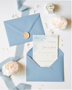 an envelope with a wax stamp on it next to some paper flowers and other items