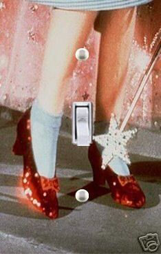 a woman's legs with red shoes and white socks in front of a light switch