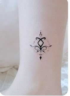 a woman's foot with a small tattoo design on the left side of her leg