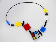 a multicolored necklace is displayed on a white surface