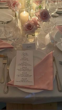 the table is set with pink napkins and silverware