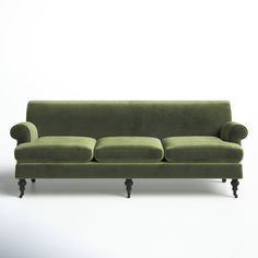 a green velvet couch sitting on top of a white floor