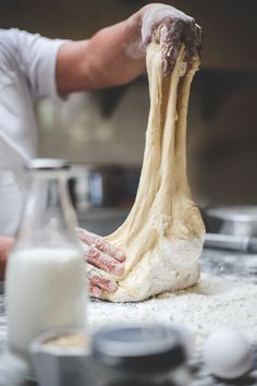 a person kneading dough on top of a table