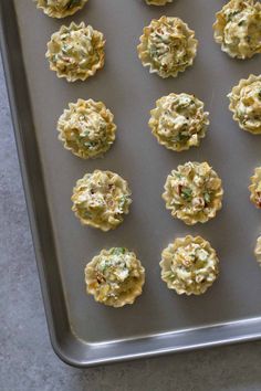 small appetizers are arranged on a cookie sheet ready to be baked in the oven