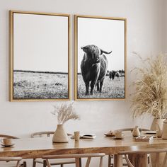 two framed pictures hang on the wall above a dining room table with chairs and vases