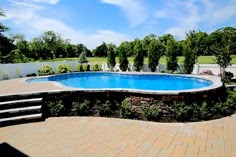 an empty swimming pool surrounded by landscaping