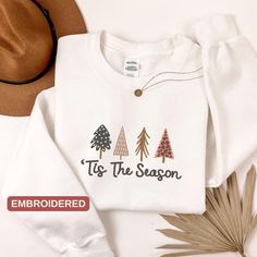 Christmas Tree Embroidered Sweatshirt, Tis The Season, Christmas, Embroidered Christmas Sweatshirt, Embroidery Christmas Gift, Gift for Her Explore our vibrant collection of embroidered clothing and personalized gifts! Before you place your order, check out our easy-to-use color and size charts. Have questions? Reach out to us anytime for expert advice on sizing and color options. We believe in quality, which is why we handpick premium brands like Gildan Softstyle, Circle, and Bella Canvas for o Embroidered Cotton Christmas Sweatshirt, Holiday Embroidered Tops As Gift, Christmas White Embroidered Tops, Embroidered Christmas Holiday Tops, Holiday Cotton Embroidered Tops, Holiday Cotton Top With Embroidery, Christmas Holiday Embroidered Sweatshirt, Embroidered Christmas Holiday Sweatshirt, Holiday Embroidered Crew Neck Sweatshirt