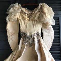 "19th C Beaded Silk Wedding Dress, Oyster Cream, ca 1892, For Restoration Project or Study LM 5/5 For Restoration or study, or repurposing bead work and or fabric (lining, etc). Amazing 19th C beaded wedding dress in oyster cream silk. Stunning bead work with glass beads and faux pearl accents. Puffy lace sleeves (removed) that come to a point at the hand. The jacket is boned and lined in silk with hook and eye closures. Long dramatic train in the back, very dramatic. Skirt is lined in a cotton/ Vintage Ball Gown Wedding Dress For Formal Occasions, Fitted Gold Victorian Dress In Vintage Style, Fitted Gold Victorian Dress, Vintage Style, Vintage Victorian Dress For Debutante Ball, Fitted Gold Victorian Vintage Dress, Vintage Victorian Ball Gown For Debutante Ball, Victorian Wedding Dress With Historical Design, Victorian Ball Gown For Vintage Events, Dramatic Skirt