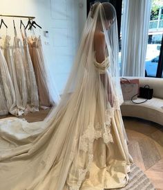 a woman in a wedding dress looking down at her veil