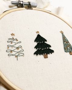 three embroidered christmas trees on a white background