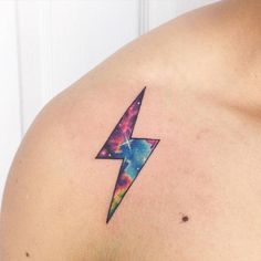 a colorful lightning bolt tattoo on the chest