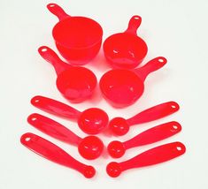 red measuring cups and spoons on a white surface