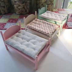 three wooden toys sitting on top of a white floor next to stuffed animals and teddy bears