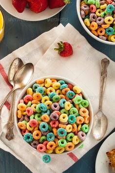 there are cereals and fruit on the table with utensils next to them