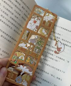 a person holding an open book with some cartoon characters on the front and back cover