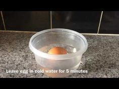 an egg is in a plastic container on the counter top, with words above it that read leave eggs in cold water for 5 minutes