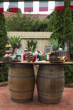 two wooden barrels sitting next to each other on top of a brick floor covered patio