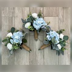 three bouquets of flowers arranged in the shape of a heart on a wooden background