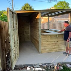 a man standing in front of a wooden shed