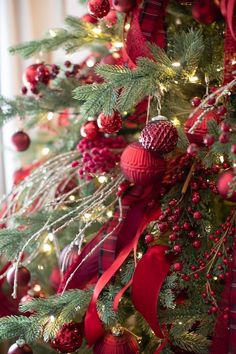 the christmas tree is decorated with red and green ornaments, ribbons, and baubles