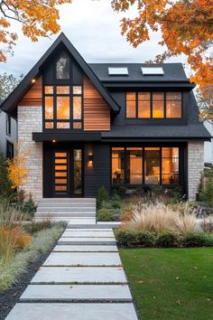 a black and white house with lots of windows in the front yard, walkway leading up to it