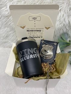 a gift box containing a coffee mug, badge and keychain with a ring security pin