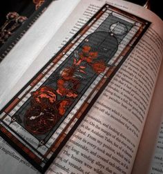 an open book with stained glass designs on it