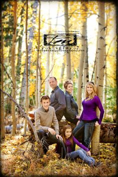 a family posing for a photo in the woods