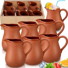 a set of six brown pitchers with strawberries and orange slices on the side, in front of a cardboard box