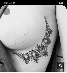 a black and white photo of a woman's breast with an intricate design on it