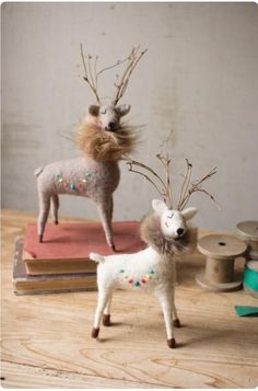 two deer figurines on top of books with sprinkles and needles