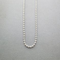 This is our Sterling Silver Ball Chain with a Spring Ring Closure. You can easily slide our charms on and off this chain. It has a shiny finish. 14" is the size recommended for children under 10 or as a choker chain.18" is the most popular size for women.20" is a popular length for men.If you are unsure of the right length for you, drape a piece of string around your neck to your preferred length, then measure the string on a ruler. Choose the available length that is closest to your measurement Silver Dog Tag Ball Chain Necklace, Silver Dog Tag Necklace With Ball Chain, Silver Charm Necklaces With Round Beads And Adjustable Chain, Silver Charm Necklace With Round Beaded Chain, Silver Chain Necklace With Round Beads And Adjustable Chain, Silver Ball Chain Necklace For Everyday, Everyday Silver Ball Chain Necklace, Ball Chain Link Necklace For Gifts, Silver Charm Necklace With Round Beads And Lobster Clasp