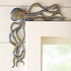 an octopus is hanging on the wall next to a white door with a blue frame