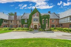 a large brick building with ivy growing on it's sides and two story windows