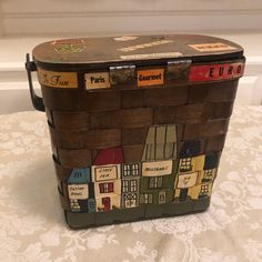 an old suitcase with some stickers on the lid sitting on a tablecloth covered surface